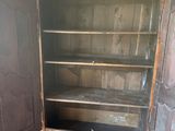 une vieille armoire en bois avec une porte vitrée, dans une pièce