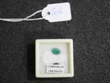 a small white box with a green stone inside of it