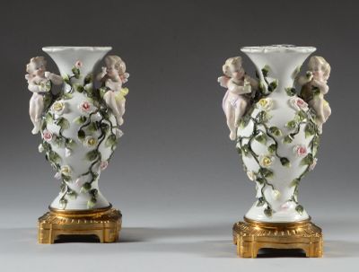 paire de vases anciens en porcelaine, ornés d'anges et de fleurs, sur des socles dorés