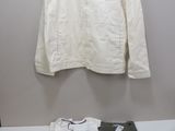 a white shirt on a hanger next to a pile of clothes