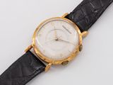 a close up of a watch on a white surface with a black strap