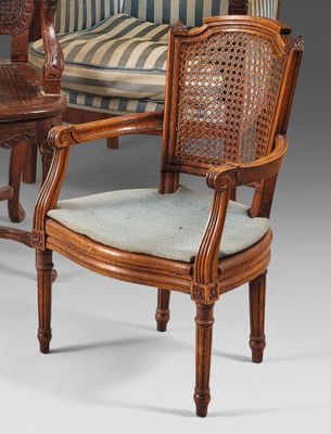 two chairs and a table in a room with a striped couch
