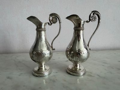 deux vases en argent posés sur une table en marbre