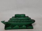a green container with a boat on it on a white surface