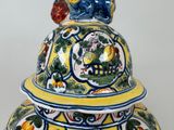 a yellow and blue vase with a bird on top