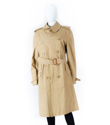 un mannequin vêtu d'un trench-coat beige et de collants noirs
