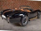 a black sports car parked in front of a brick wall
