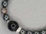 un gros plan sur un bracelet composé d'une perle noire et de perles argentées