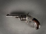 a close up of a gun on a table with a gray background