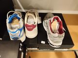 three pairs of shoes sitting on top of a box