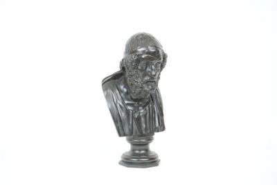 une statue représentant un homme barbu sur un socle