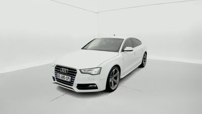 une Audi blanche garée dans une pièce blanche aux murs blancs