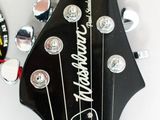 a close up of an electric guitar with a clock on the wall