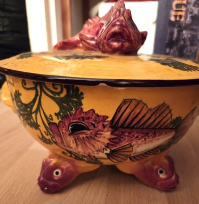 un bol jaune orné d'un poisson, posé sur une table
