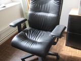 une chaise de bureau noire placée devant une fenêtre