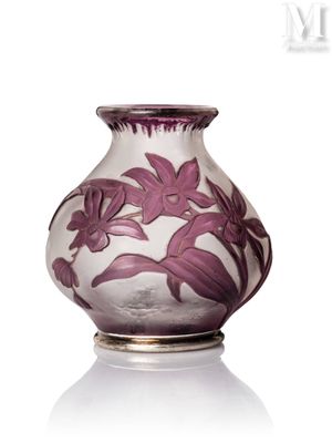 un vase violet orné de fleurs, posé sur une surface blanche