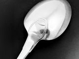 black and white photograph of a spoon on a black surface
