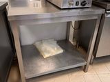 stainless steel table with a microwave on top of it in a kitchen