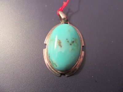 une photo d'un pendentif orné d'une pierre turquoise