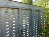 a metal fence that has holes in the top of it