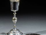 une coupe en argent et une assiette en argent posées sur une table