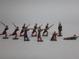 Plusieurs figurines de petits soldats sont disposées sur une surface blanche