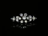 a close up of a diamond and pearl broochle on a black surface