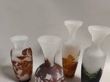 several vases with different designs are lined up on a white surface