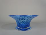 un saladier en verre bleu posé sur une table blanche