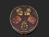 a small round box with five different faces on it