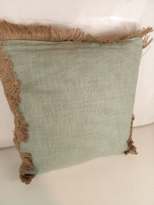 deux coussins verts aux bords effilochés posés sur une surface blanche