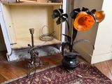 un vase avec des fleurs et une lampe posée par terre
