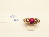 a close up of a gold ring with a red stone on it