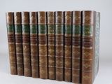 six vieux livres alignés sur une surface blanche