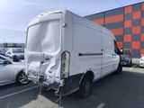 a white van parked in a parking lot next to a building