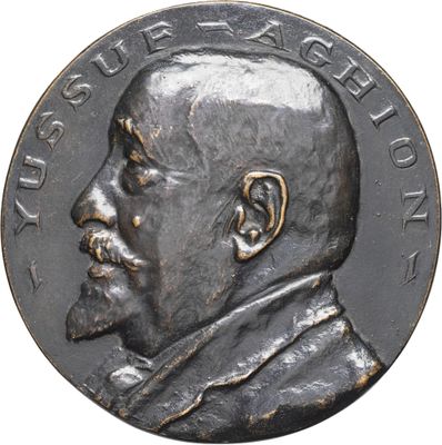 an image of a silver medal with a man ' s face on it