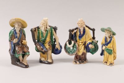 three chinese figurines of men with hats and carrying bags