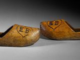 pair of wooden clogs with initials and a heart carved into them