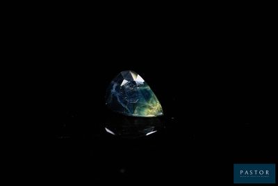 a blue and green diamond on a black surface