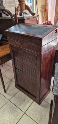une petite armoire en bois posée à même le sol dans une pièce