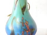 a blue vase with a flower in it sitting on a table