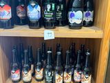 Des bouteilles de bière sont posées sur une étagère en bois dans un magasin.