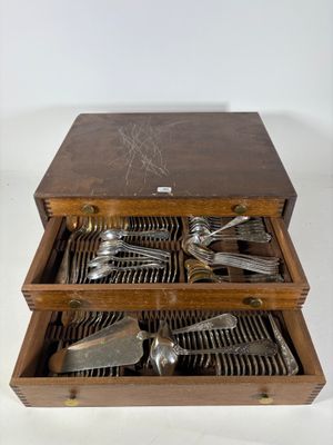 une boîte en bois contenant de l'argenterie sur une surface blanche