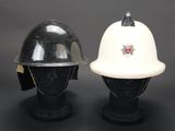 pair of helmets on mannequin heads on a black background