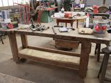 un établi au milieu d'un atelier, sur lequel sont posés des outils