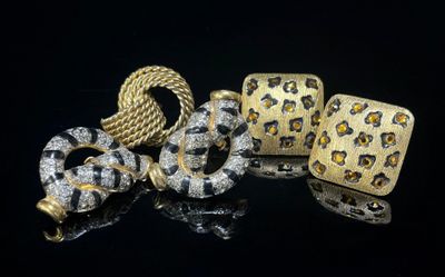 un gros plan sur deux bijoux en or et en diamants posés sur une surface noire
