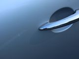 a close up of a door handle on a silver car