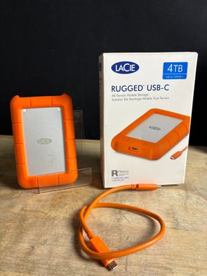 an orange hard drive sitting on top of a wooden table next to a box