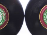 pair of black vases with green and red labels on them