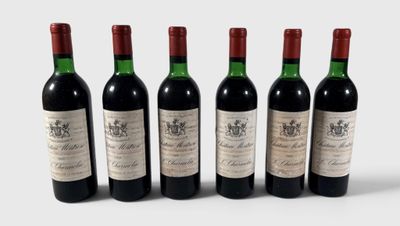 quatre bouteilles de vin sont alignées sur une surface blanche